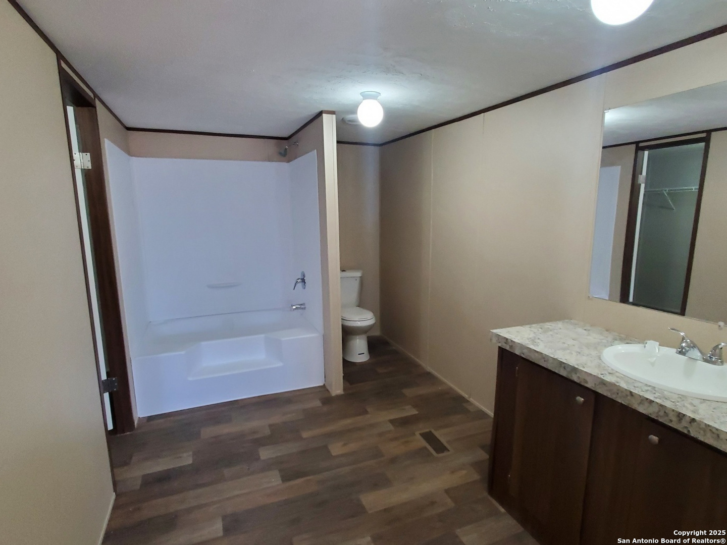 61 Post Oak Road, Unit A La Vernia, TX 78121 - Photo 6 of 11 a bathroom with a granite countertop sink and a mirror
