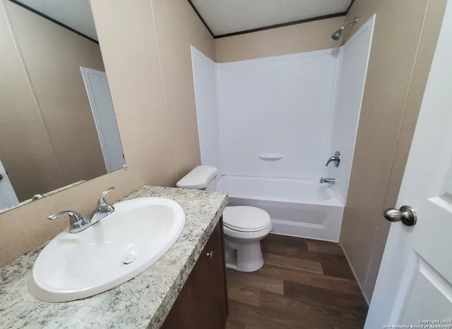 a bathroom with a granite countertop sink toilet and shower