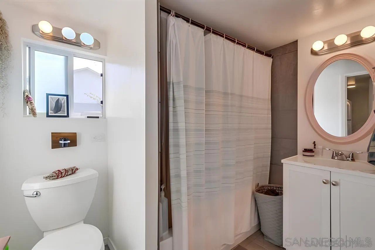 4667-69 35th Street San Diego, CA 92116 - Photo 25 of 29 a bathroom with a toilet sink vanity and mirror