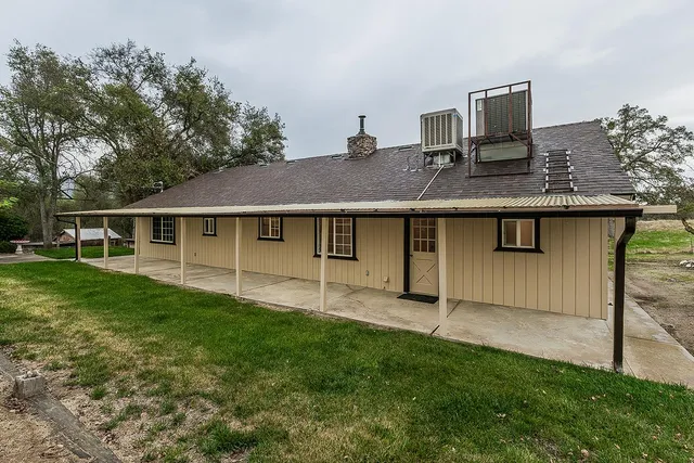 a view of an empty room with wooden floor fireplace and a window