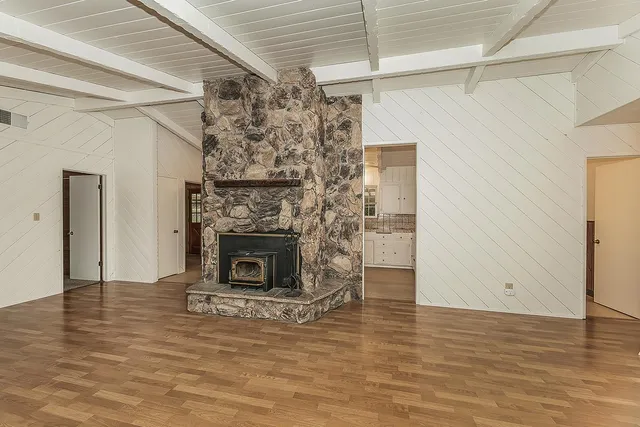 a view of empty room with wooden floor and fireplace