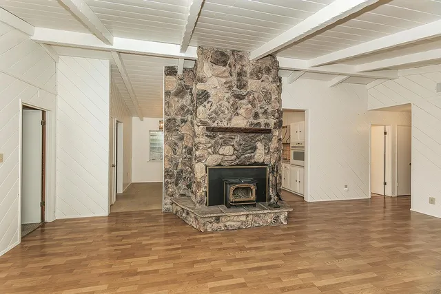 a view of a livingroom with wooden floor and a fireplace