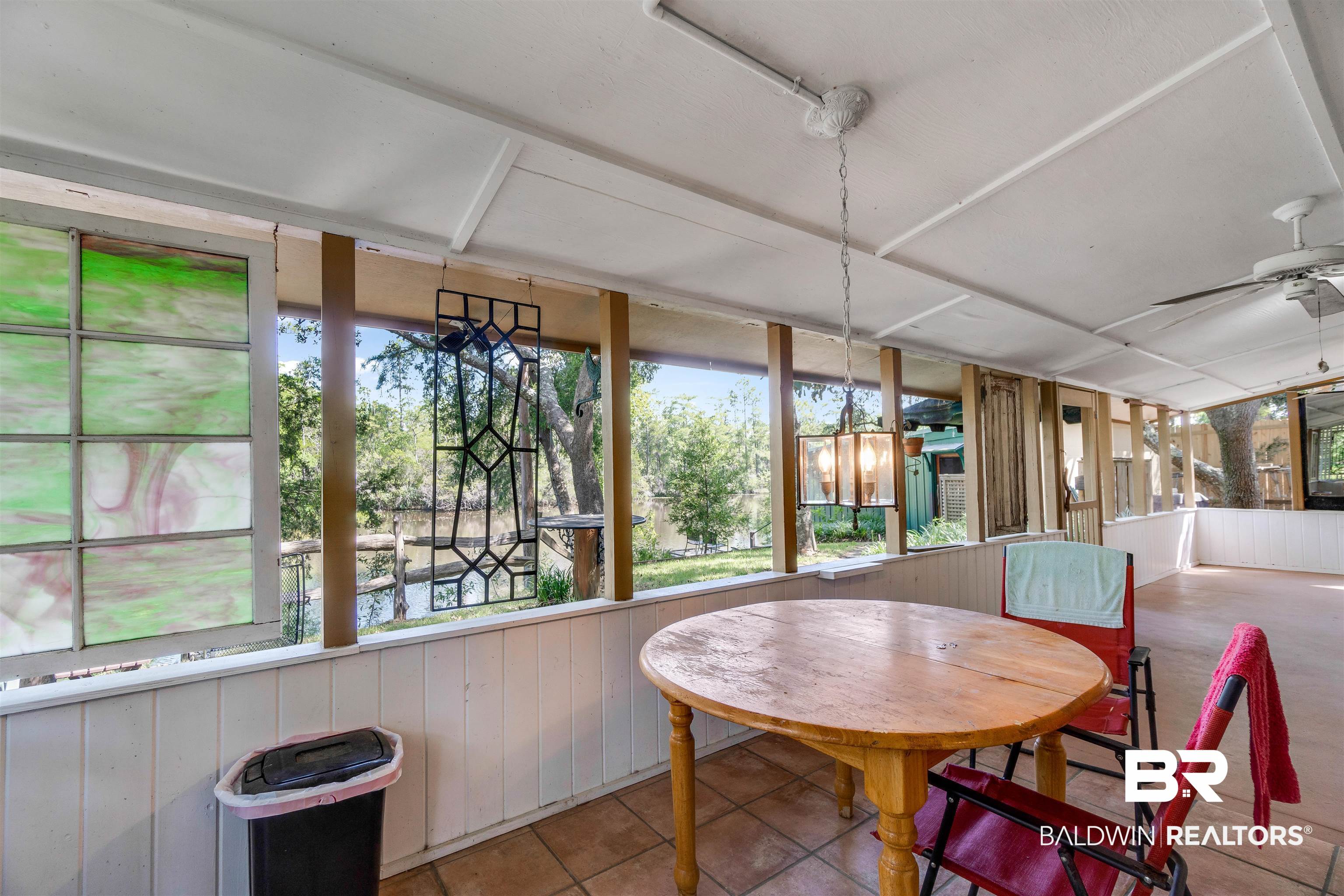 34341 Lost River Road Seminole, AL 36574 - Photo 22 of 36 Sunroom featuring ceiling fan, tile patterned floors, and wooden walls