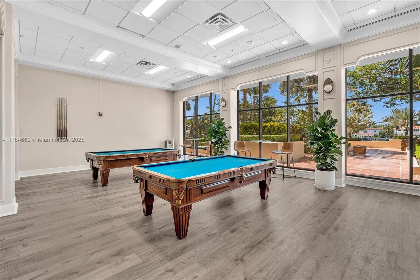 5600 Collins Avenue, Unit 10J Miami Beach, FL 33140 - Photo 18 of 20 a room with furniture pool table wooden floor and windows