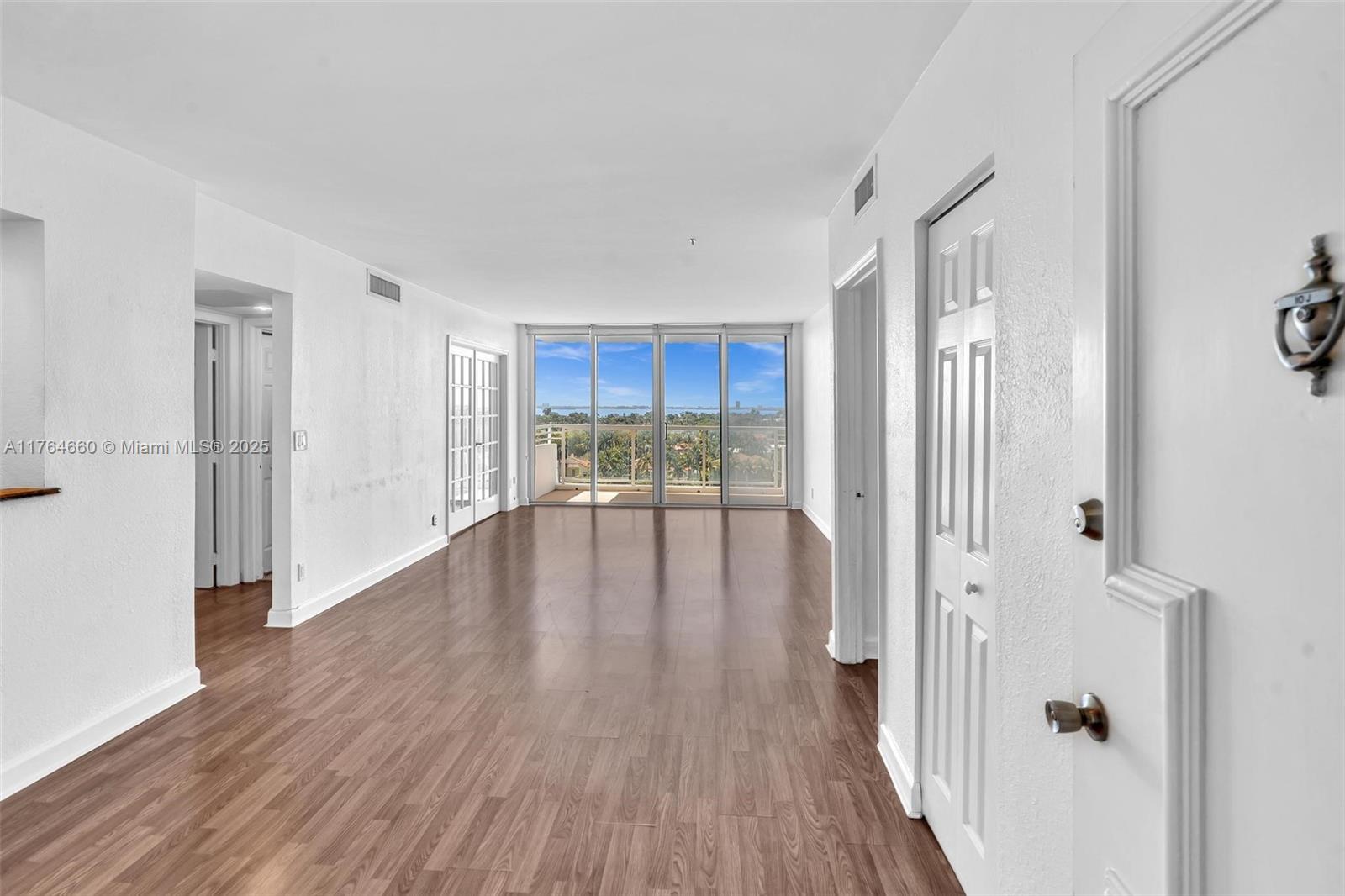 5600 Collins Avenue, Unit 10J Miami Beach, FL 33140 - Photo 2 of 20 a view of a hallway with wooden floor and a cabinet