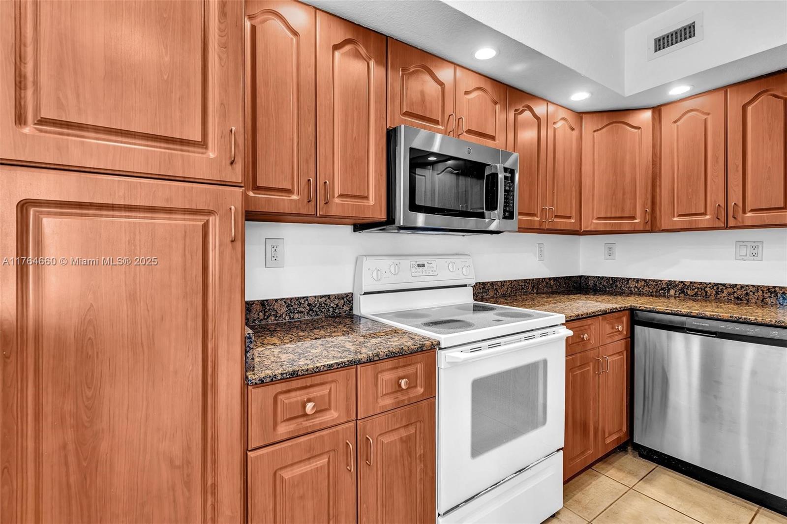 5600 Collins Avenue, Unit 10J Miami Beach, FL 33140 - Photo 4 of 20 a kitchen with granite countertop stainless steel appliances a stove a microwave and cabinets