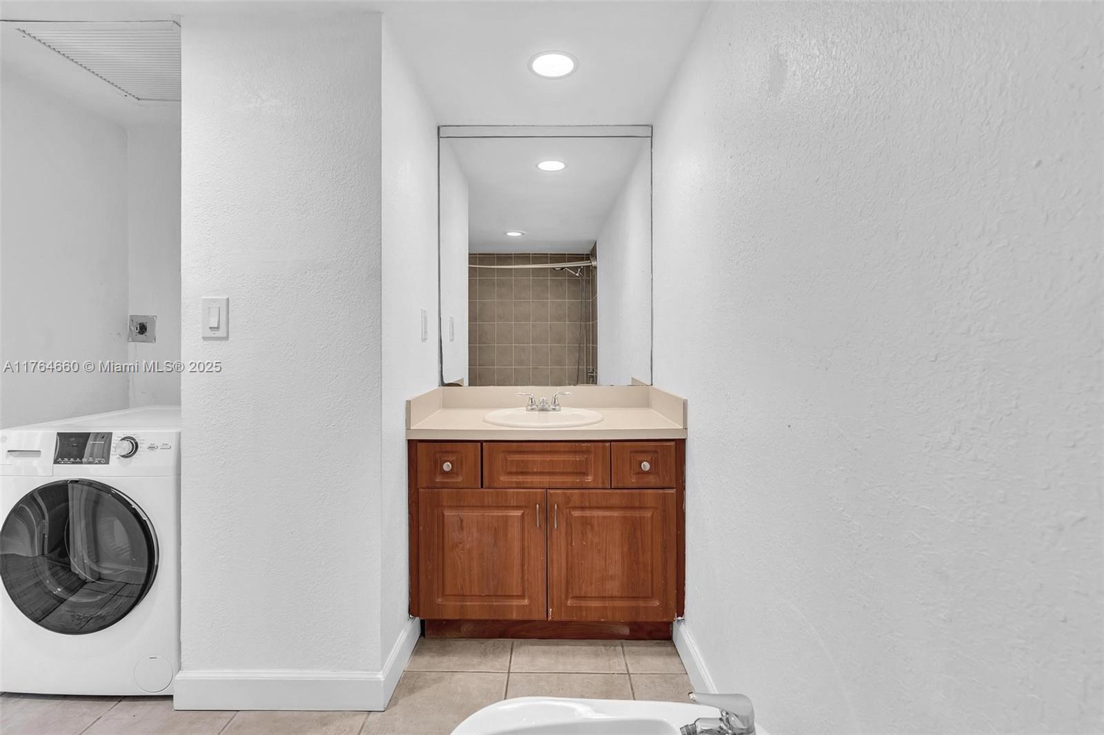 5600 Collins Avenue, Unit 10J Miami Beach, FL 33140 - Photo 6 of 20 a view of a bathroom with washing machine and sink