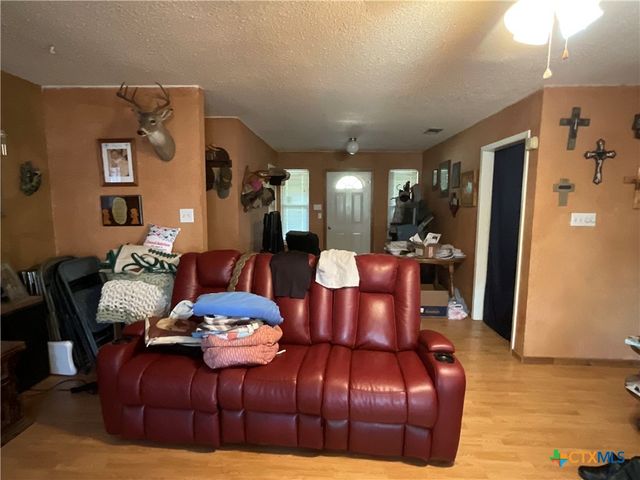 a living room with furniture a flat screen tv and a window