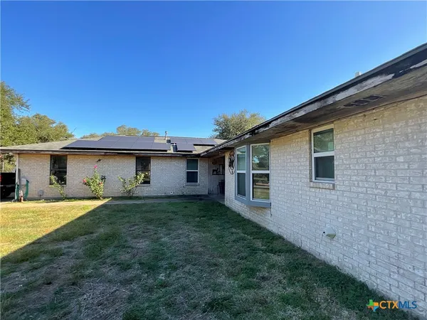 a view of a house with a backyard