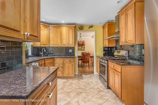 a kitchen with stainless steel appliances granite countertop a stove a sink and a microwave