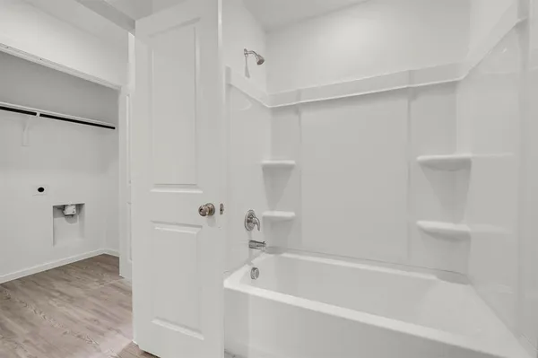 a white bath tub sitting next to a shower