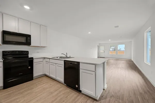 a kitchen with granite countertop a stove top oven and sink