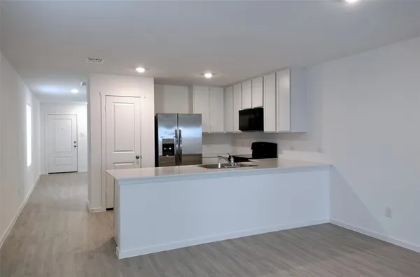 a kitchen with stainless steel appliances a refrigerator sink and microwave