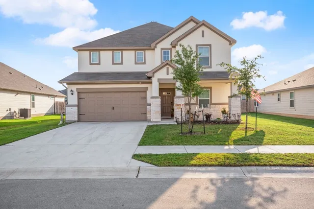 a front view of a house with a yard and garage