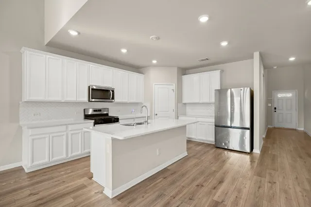 a kitchen with sink cabinets and wooden floor