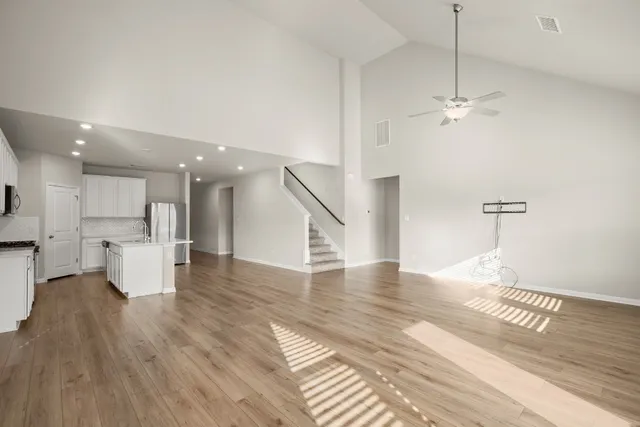 an empty room with a window and a fan