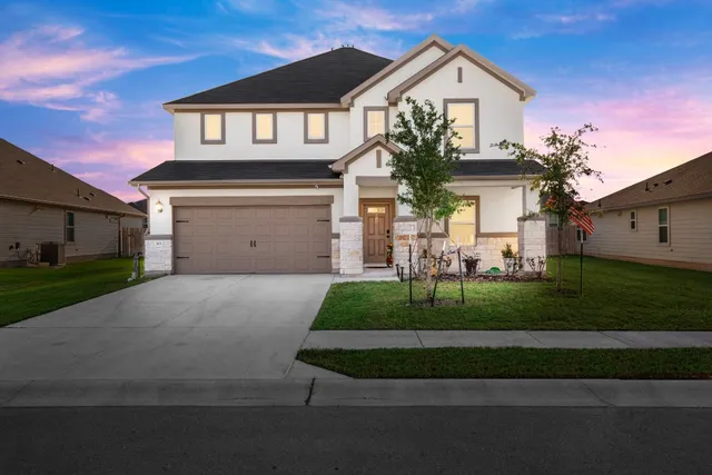 a front view of a house with a yard and garage