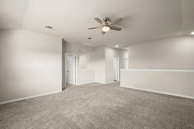 an empty room with fan and windows