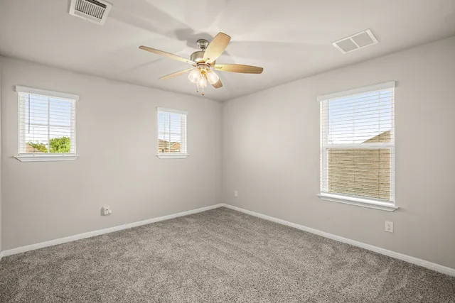 an empty room with a window and a fan