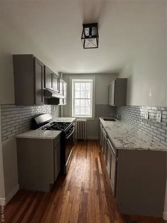 a kitchen with granite countertop a sink stove and refrigerator