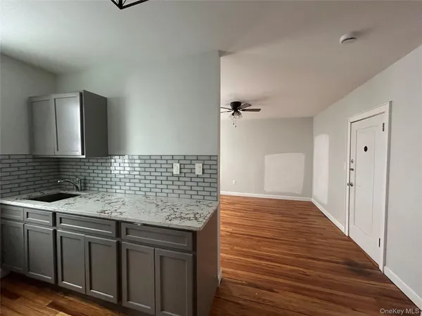 a kitchen with granite countertop a sink and wooden cabinets