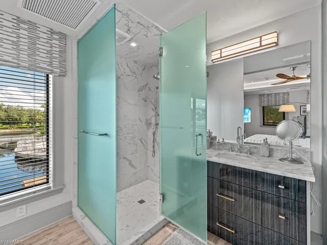 a bathroom with a granite countertop sink a mirror and a shower