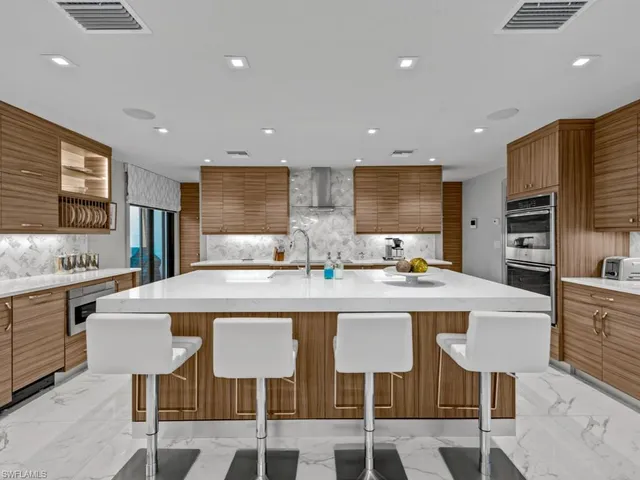a kitchen with stainless steel appliances granite countertop a table chairs sink refrigerator and microwave