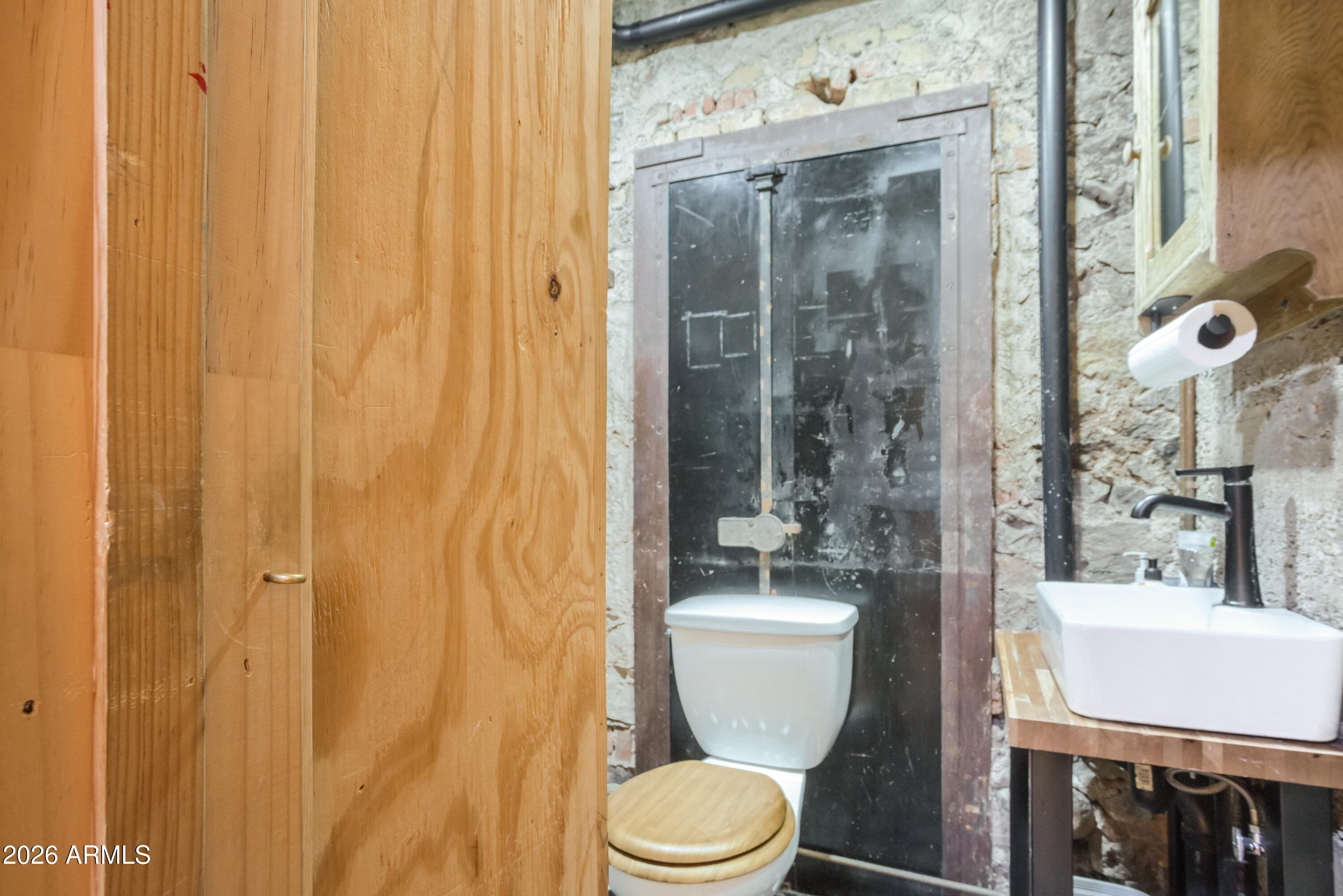 40 Main Street Bisbee, AZ 85603 - Photo 15 of 37 a bathroom with a toilet a sink and a shower curtain