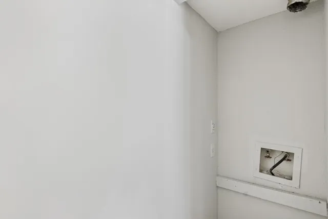 an empty room with a window and ceiling fan
