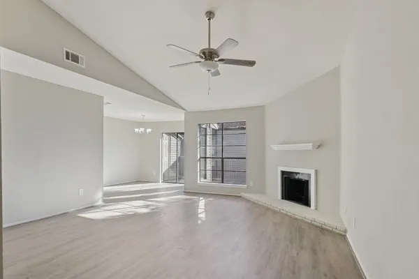 an empty room with windows and fireplace