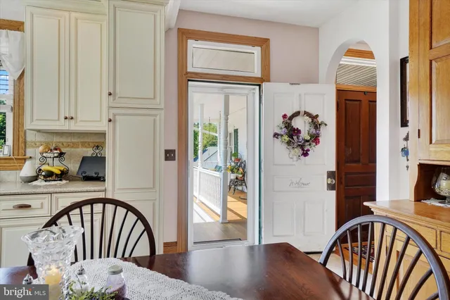 a view of staircase with a dining table chairs and a large window