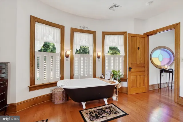 a view of a hallway with furniture and wooden floor