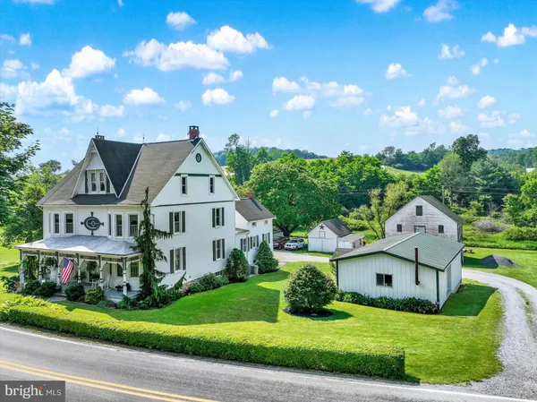 a view of a house with a big yard and large trees