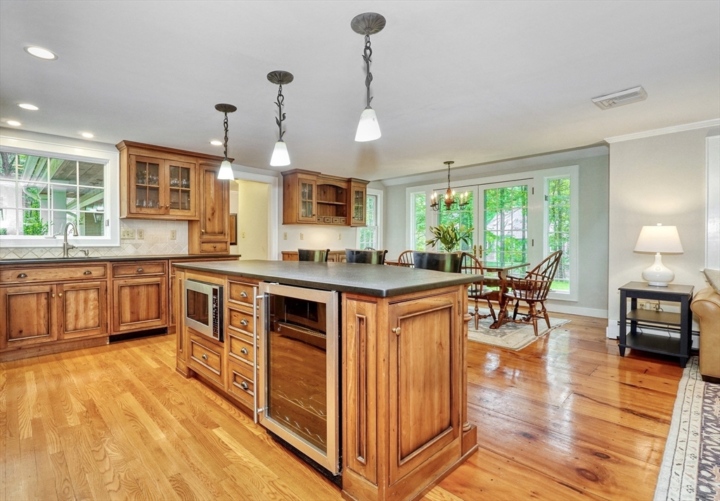 43 Old Pickard Road Concord, MA 01742 - Photo 6 of 27 a open kitchen with stainless steel appliances granite countertop a stove top oven a sink dishwasher a dining table and chairs with wooden floor