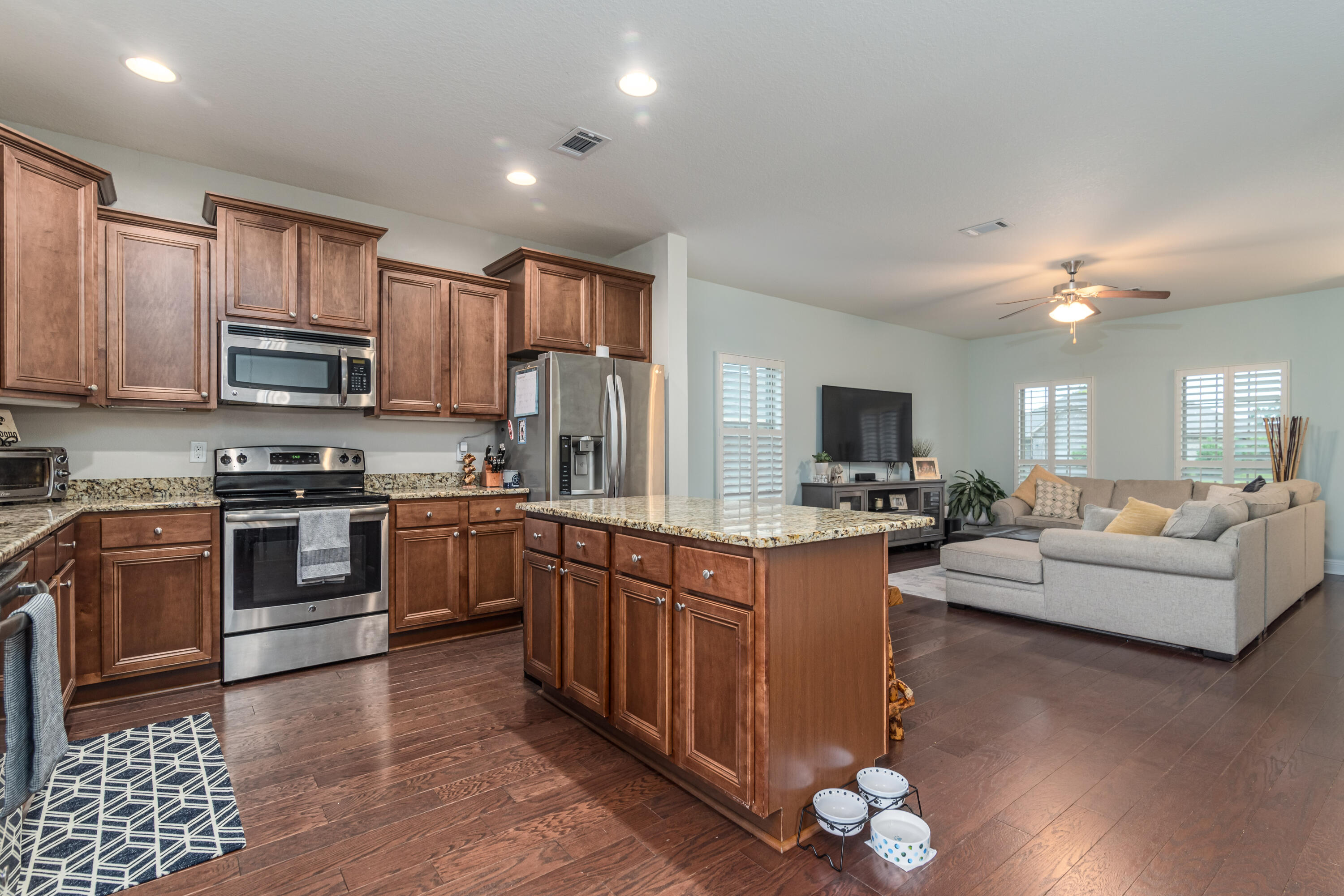 142 Pin Oak Loop Santa Rosa Beach, FL 32459 - Photo 30 of 56 a large kitchen with stainless steel appliances granite countertop a stove top oven a sink dishwasher a dining table and chairs with wooden floor