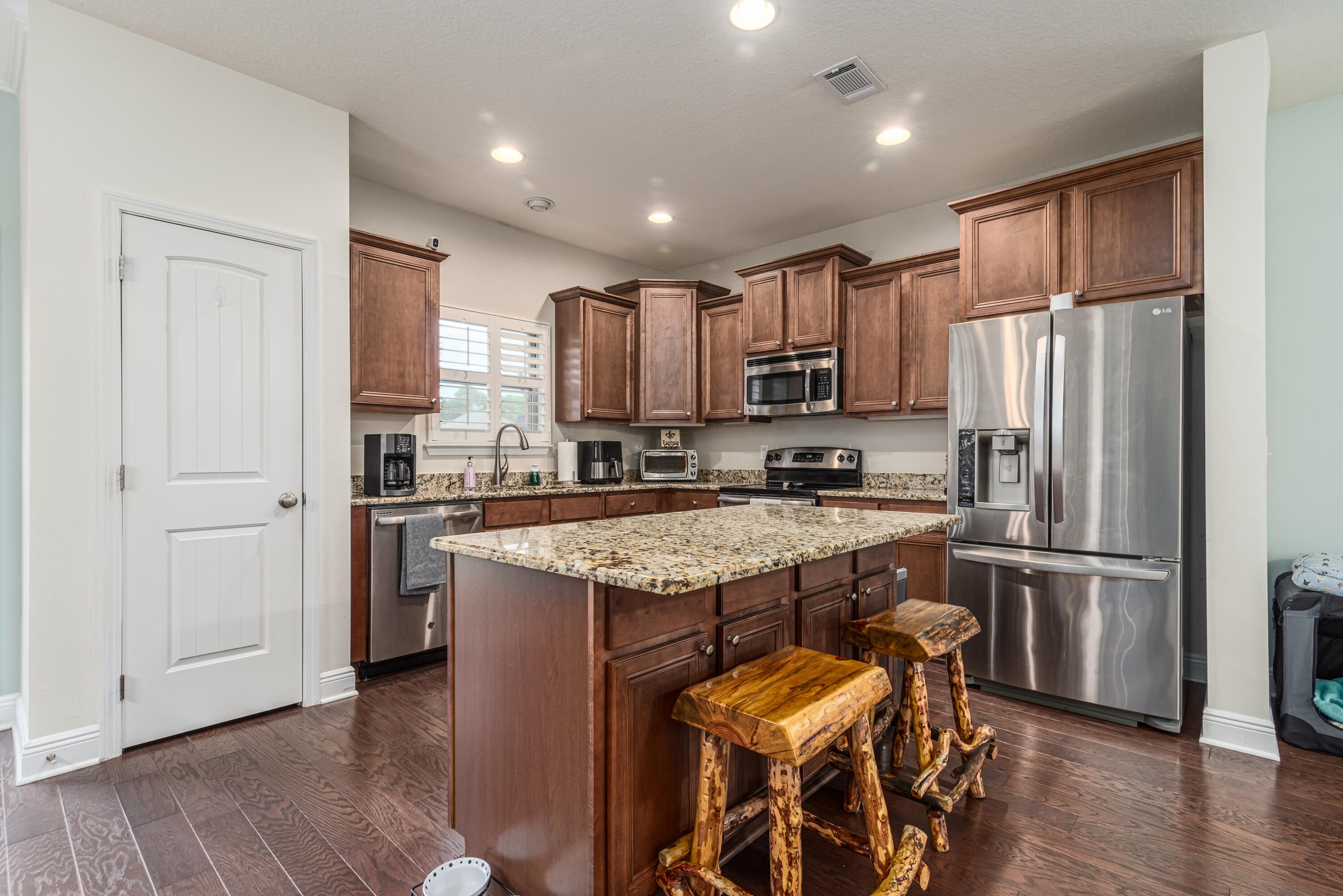 142 Pin Oak Loop Santa Rosa Beach, FL 32459 - Photo 31 of 56 a kitchen with stainless steel appliances granite countertop a refrigerator a sink dishwasher a stove and a refrigerator with wooden floor