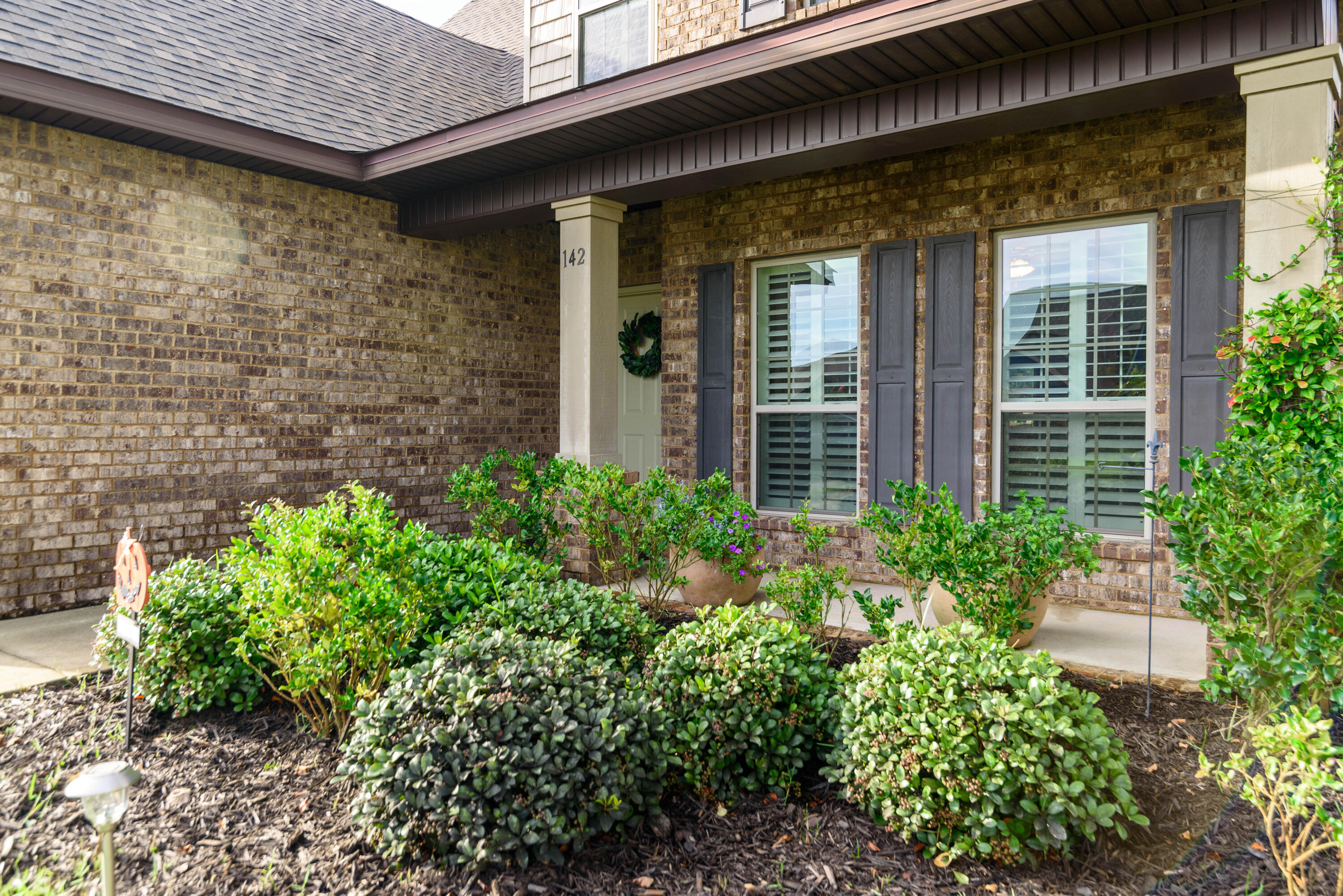 142 Pin Oak Loop Santa Rosa Beach, FL 32459 - Photo 5 of 56 front view of a brick house with a large window and potted plants