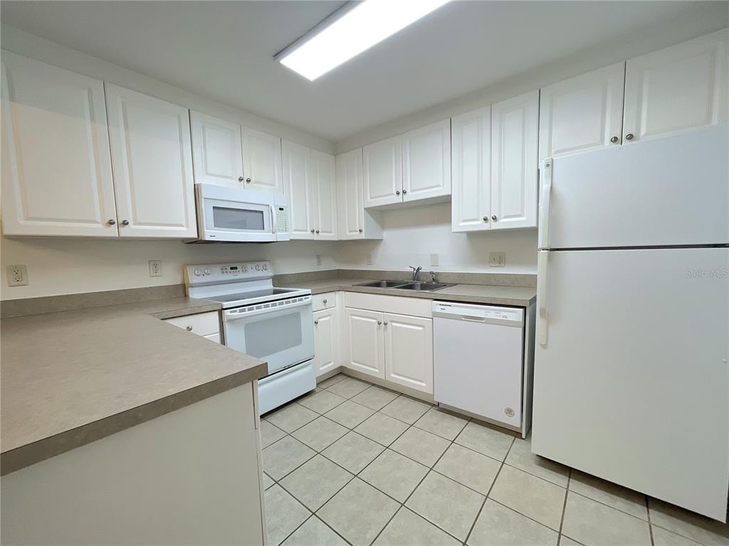 501 Southwest 75th Street, Unit C4 Gainesville, FL 32607 - Photo 16 of 37 a kitchen with white cabinets and white appliances