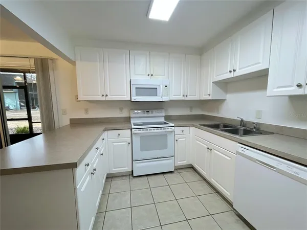 a kitchen with granite countertop white cabinets and white appliances