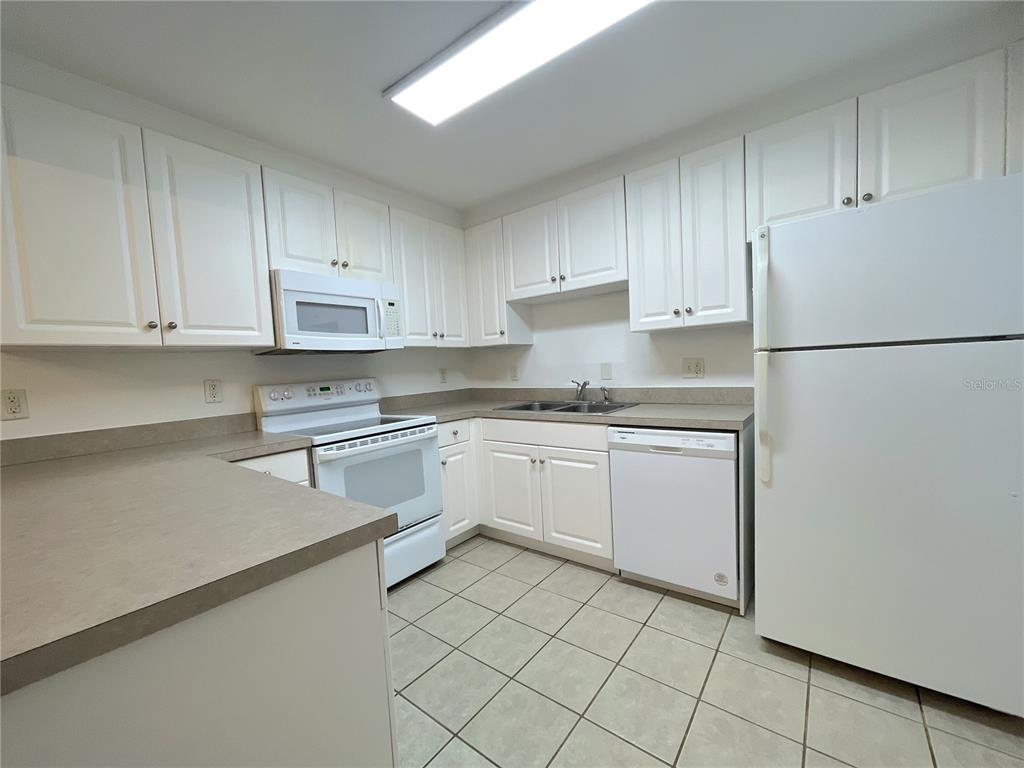 501 Southwest 75th Street, Unit C4 Gainesville, FL 32607 - Photo 20 of 37 a kitchen with white cabinets and white appliances
