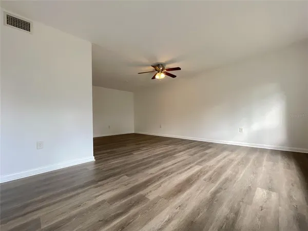 a view of a room with wooden floor and white walls