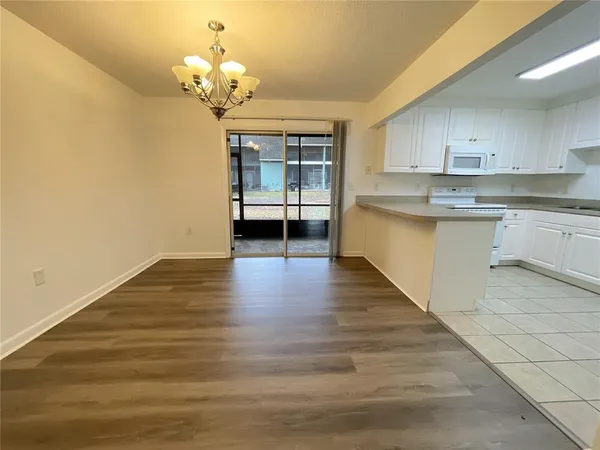 a kitchen with a white cabinets and chandelier
