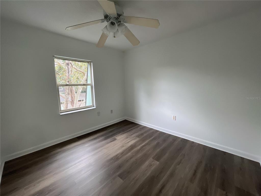 501 Southwest 75th Street, Unit C4 Gainesville, FL 32607 - Photo 8 of 37 an empty room with a window and a ceiling fan