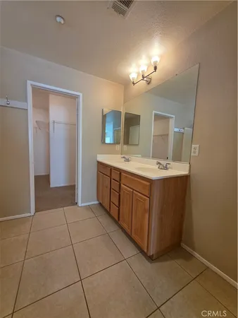 a spacious bathroom with a double vanity sink and a mirror