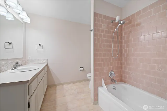 a bathroom with a tub sink and mirror