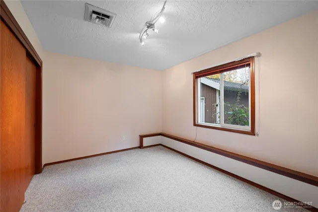 an empty room with a window and a ceiling fan
