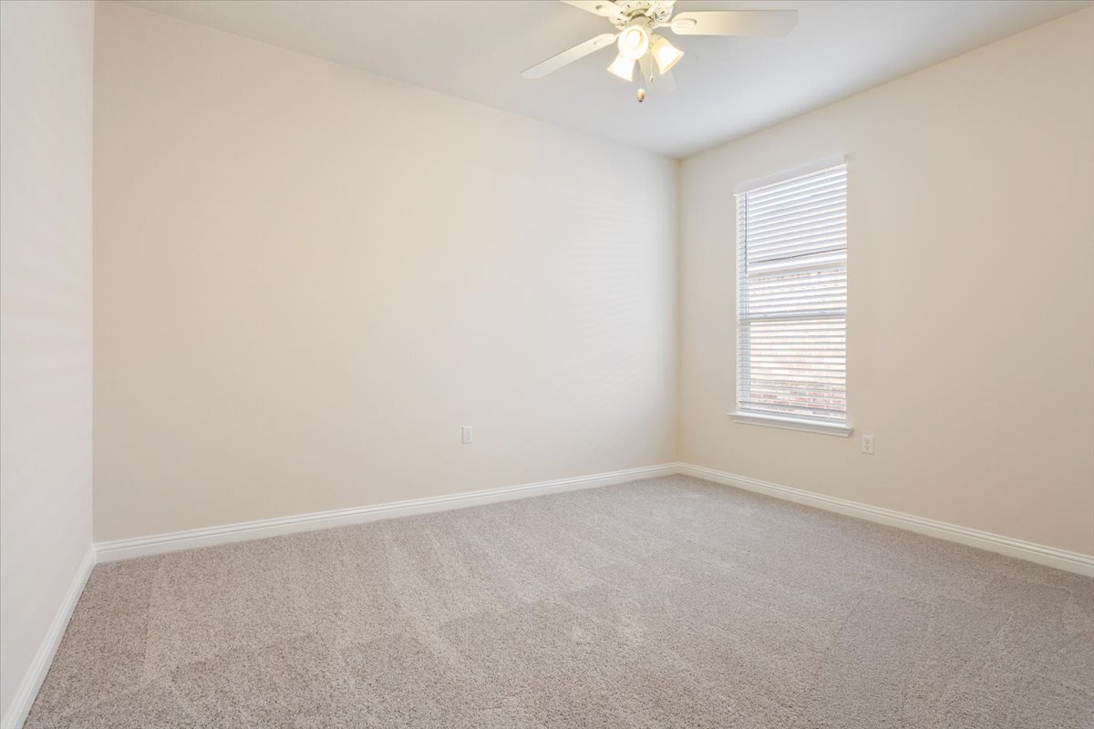 108 Cathedral Mountain Pass Georgetown, TX 78633 - Photo 27 of 36 an empty room with a chandelier fan and windows
