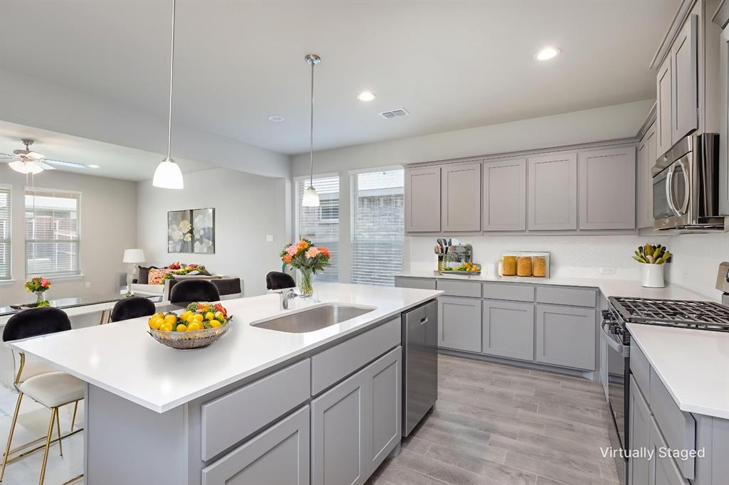 14621 Bootes Drive Haslet, TX 76052 - Photo 15 of 40 Kitchen featuring gray cabinets, stainless steel appliances, pendant lighting, an island with sink, and recessed lighting