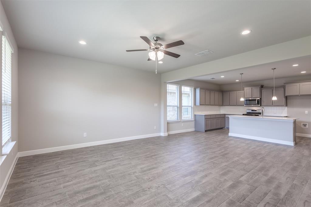 14621 Bootes Drive Haslet, TX 76052 - Photo 40 of 40 Kitchen with gray cabinets, an island with sink, open floor plan, light countertops, and ceiling fan