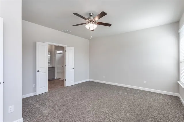 an empty room with closet and ceiling fan